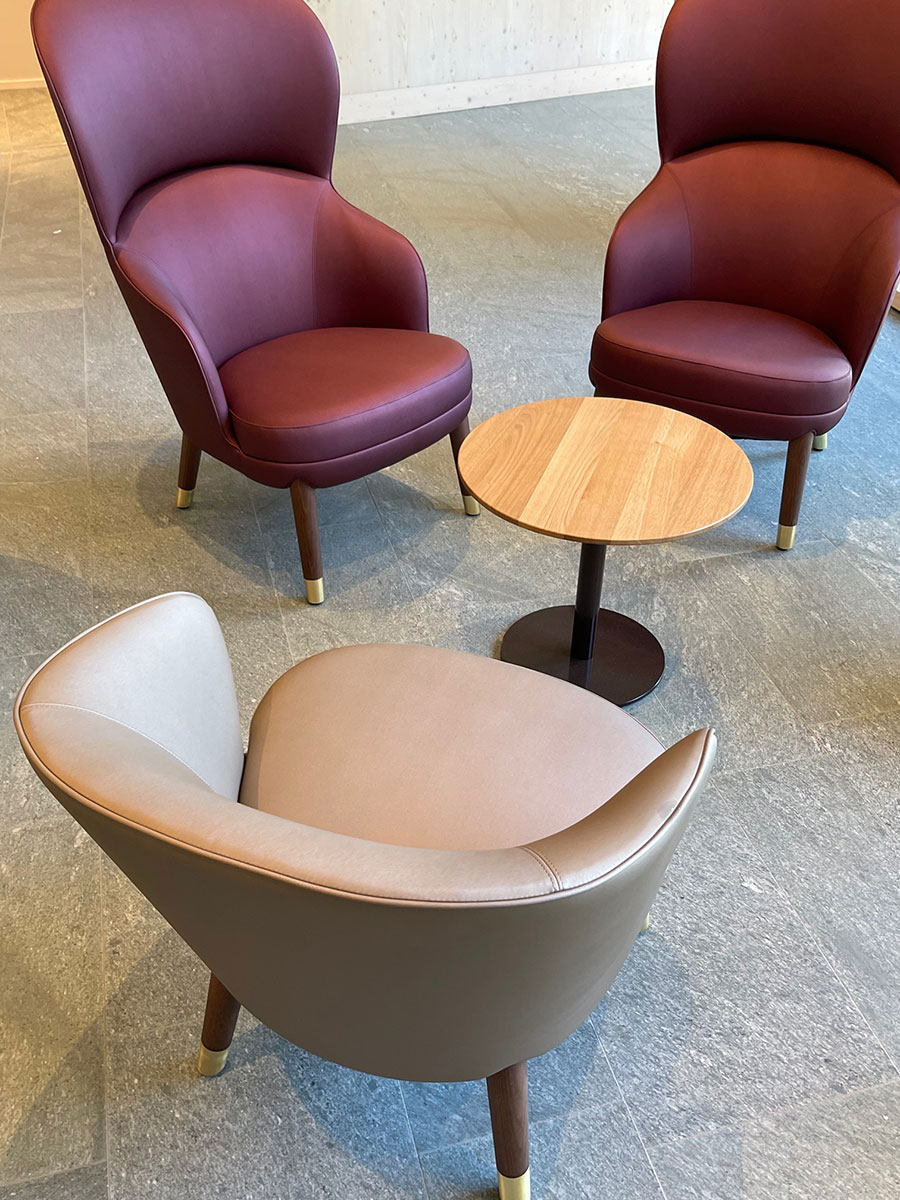 Draufsicht auf Sessel in Beige und Bordeauxrot im Eingangsbereich.