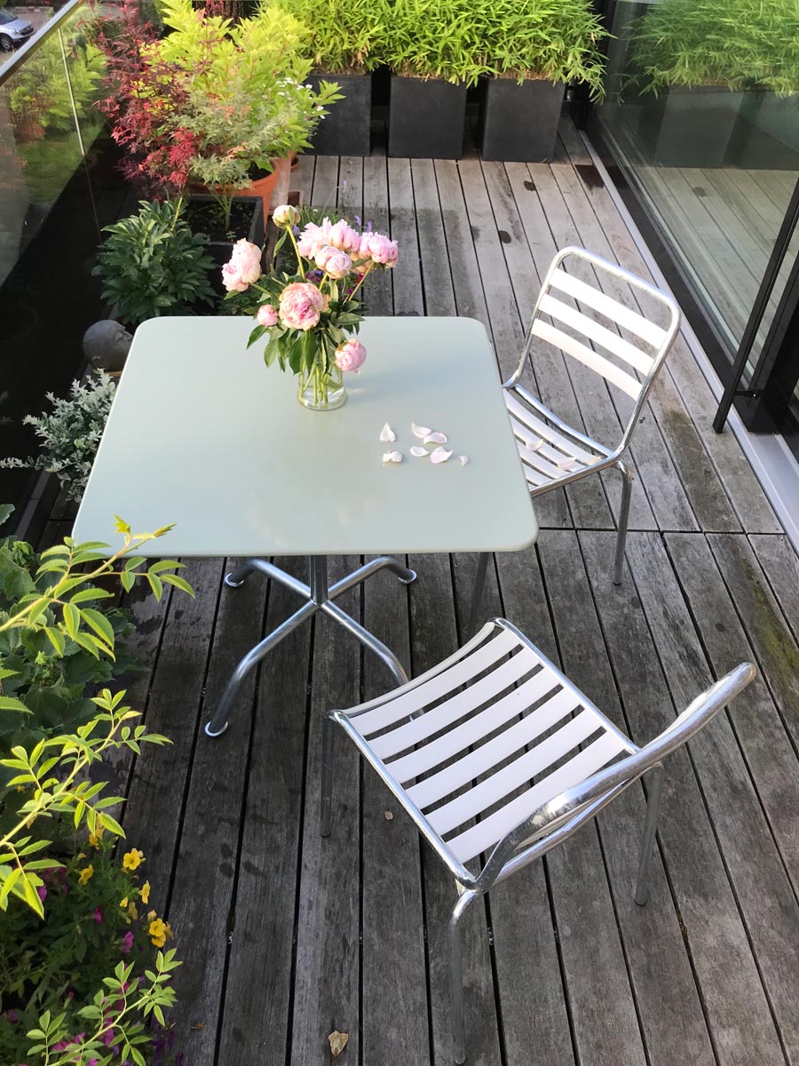 Balkon mit quadratischem Bättig Gartentisch in Heugrün mit zwei Bättig Gartenstühlen in Beige