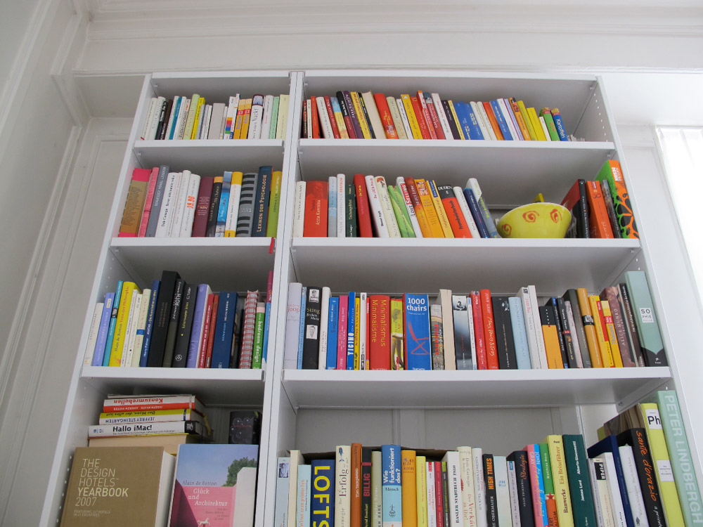 Weisses Lehni Regal in einer privaten Wohnung, gefüllt mit vielen bunten Büchern