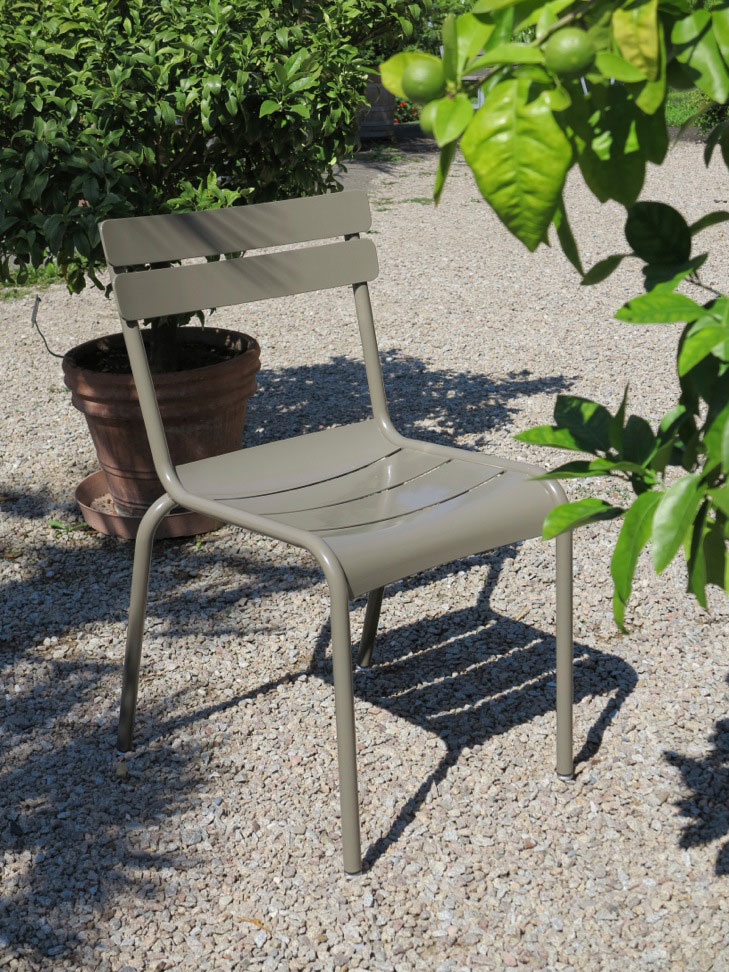 Luxembourg Gartenstuhl in der Hausfarbe von minimal in einem mediterranen Park mit einem Zitronenbaum im Vordergrund